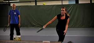 Vår tennistränare Larbi instruerar en kund under en tennislektion.